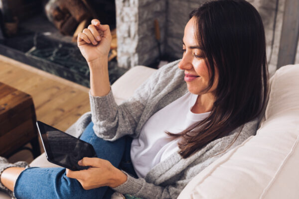 a girl sitting on a couch and using her phone