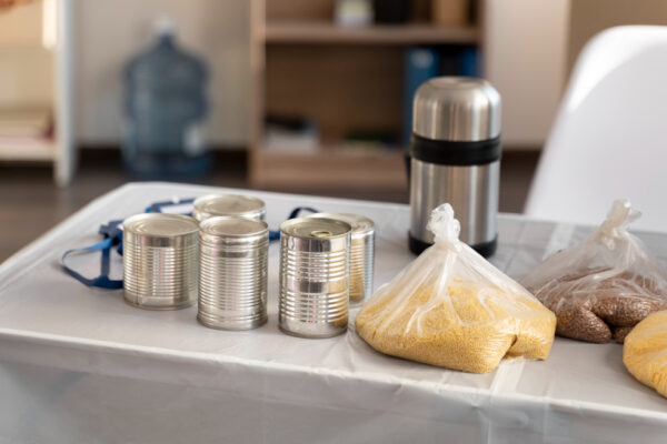 A table displaying a multi-layer food grid of assorted foods and a stylish stainless steel water bottle for hydration.